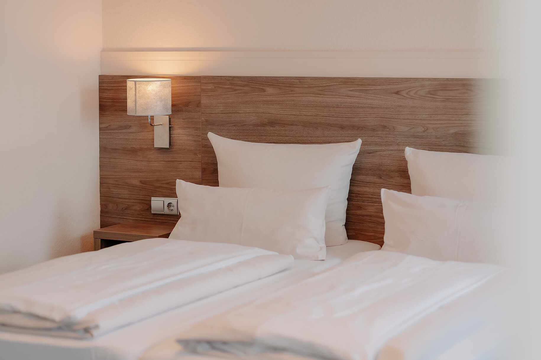 Zwei bezogene Betten mit Holzkopfteil im Parkhotel Lingen