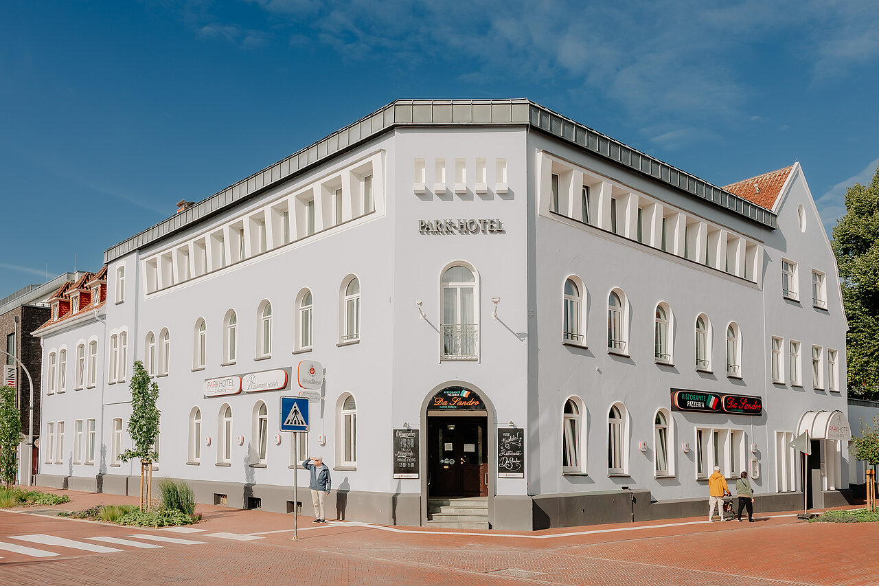 Außenansicht des Parkhotel Lingen by Hackmann mit heller historischer Fassade an einer Straßenkreuzung.