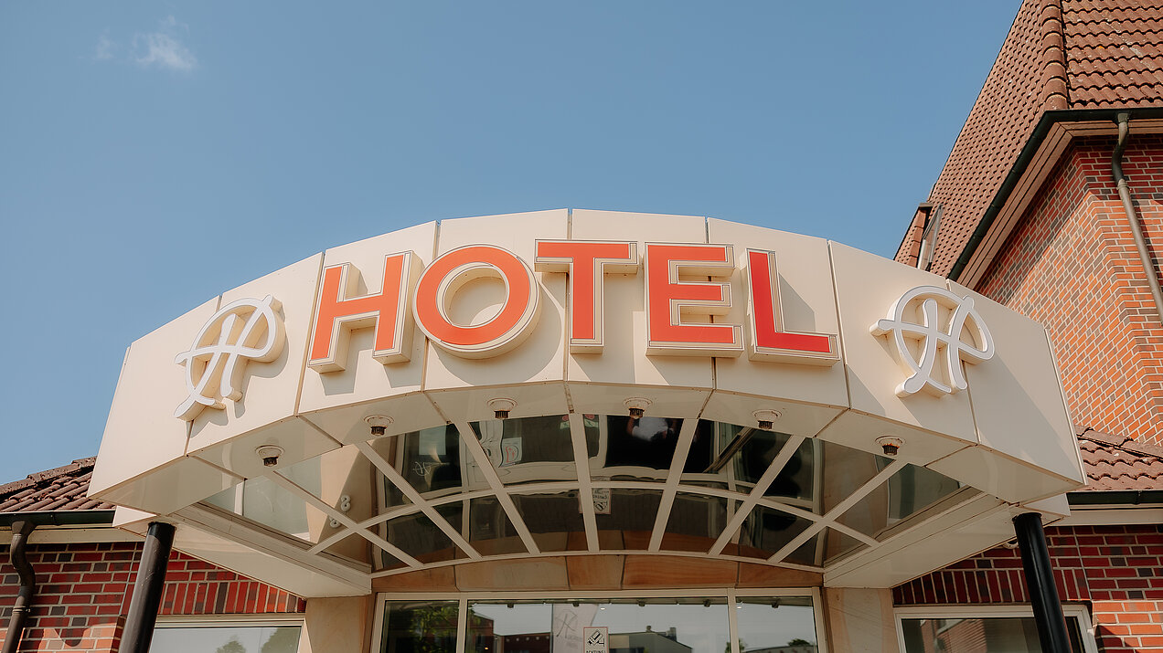 Main entrance of CASCADA Hotel Rheine with illuminated hotel sign
