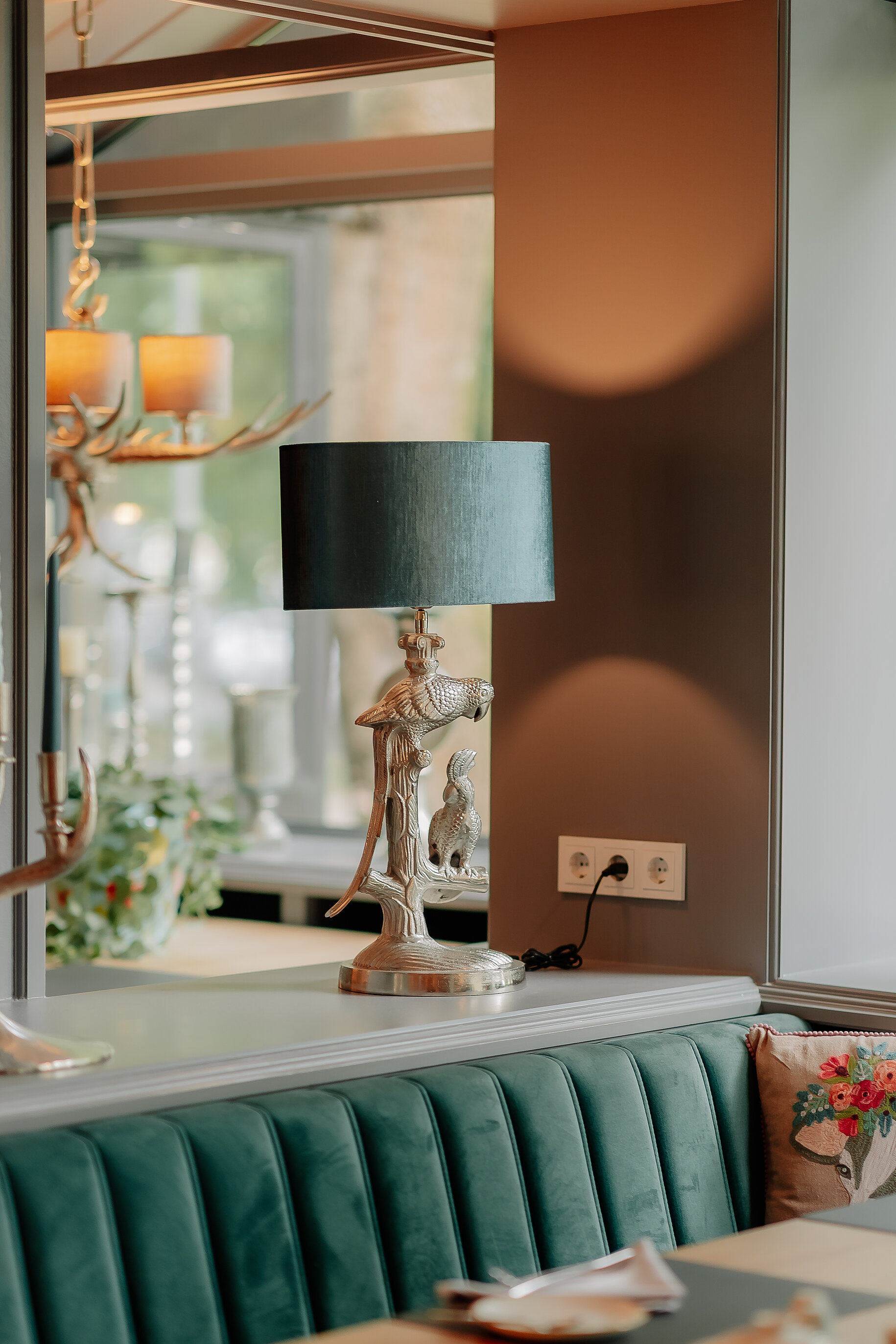 Designlampe mit Papageienfigur auf einer Fensterbank im Stadthotel Borken